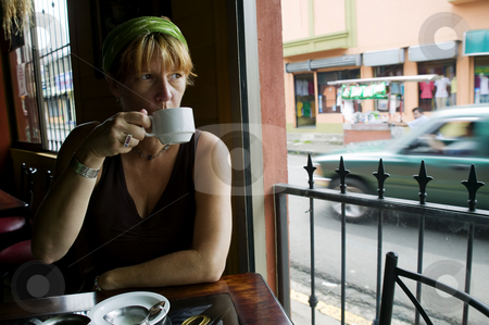 To use this stock image in your creative project, please select the size you need over to the right and click the "Add to Cart" button.
Your downloaded image will come with the Cutcaster watermark removed so don’t worry about the watermark you see on this page. Coffee in Costa Rica stock photo, Woman drinks coffee in an Alejuela Costa Rica cafe by Scott Griessel