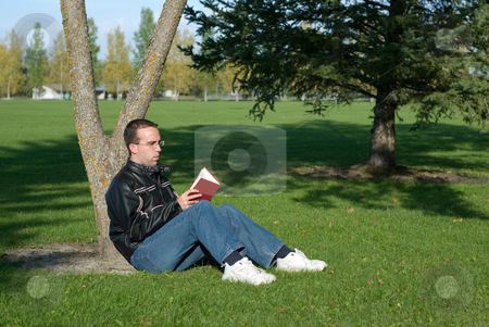 To use this stock image in your creative project, please select the size you need over to the right and click the "Add to Cart" button.
Your downloaded image will come with the Cutcaster watermark removed so don’t worry about the watermark you see on this page. Man Reading By A Tree stock photo, A young man resting by a tree and reading a book by Richard Nelson
