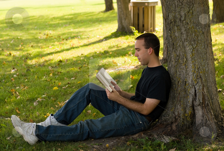 To use this stock image in your creative project, please select the size you need over to the right and click the "Add to Cart" button.
Your downloaded image will come with the Cutcaster watermark removed so don’t worry about the watermark you see on this page. Reading A Book stock photo, A young man relaxing under a tree, reading a book by Richard Nelson