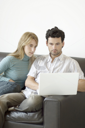 To use this stock image in your creative project, please select the size you need over to the right and click the "Add to Cart" button.
Your downloaded image will come with the Cutcaster watermark removed so don’t worry about the watermark you see on this page. Couple relaxing at home with a laptop computer stock photo, A young couple relaxing at home on the sofa with a laptop computer by Lee Torrens