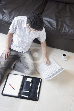 To use this stock image in your creative project, please select the size you need over to the right and click the "Add to Cart" button.
Your downloaded image will come with the Cutcaster watermark removed so don’t worry about the watermark you see on this page. Man Telecommuting stock photo, A young professional businessman working from home with laptop and a coffee by Lee Torrens