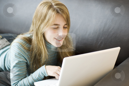 To use this stock image in your creative project, please select the size you need over to the right and click the "Add to Cart" button.
Your downloaded image will come with the Cutcaster watermark removed so don’t worry about the watermark you see on this page. Woman using laptop at home stock photo, A young woman relaxed and laying forward on a sofa with her laptop by Lee Torrens
