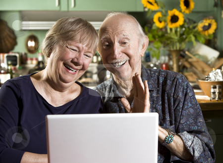 To use this stock image in your creative project, please select the size you need over to the right and click the "Add to Cart" button.
Your downloaded image will come with the Cutcaster watermark removed so don’t worry about the watermark you see on this page. Smiling Senior Couple with a Laptop Computer stock photo, Smiling Senior Couple in their Dining Room with a Laptop Computer by Scott Griessel
