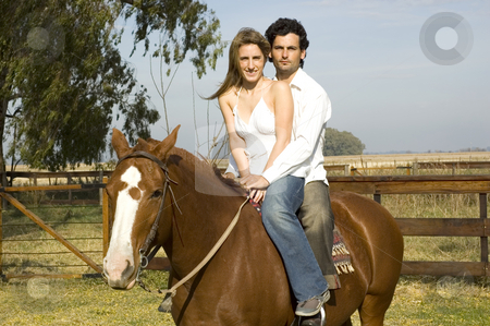 To use this stock image in your creative project, please select the size you need over to the right and click the "Add to Cart" button.
Your downloaded image will come with the Cutcaster watermark removed so don’t worry about the watermark you see on this page. Couple on horseback stock photo, A young couple riding their horse on a rural farm on a cloudy day by Lee Torrens