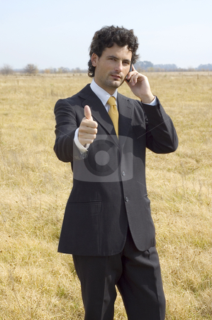 To use this stock image in your creative project, please select the size you need over to the right and click the "Add to Cart" button.
Your downloaded image will come with the Cutcaster watermark removed so don’t worry about the watermark you see on this page. Business man with thumbs up stock photo, A young businessman on a phone call in a dry field gives the thumbs up. by Lee Torrens