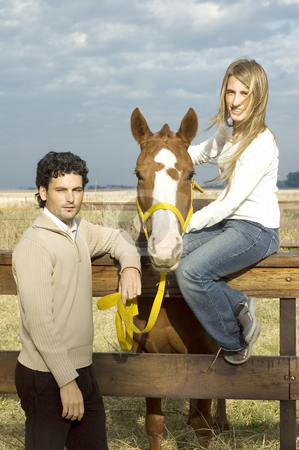 To use this stock image in your creative project, please select the size you need over to the right and click the "Add to Cart" button.
Your downloaded image will come with the Cutcaster watermark removed so don’t worry about the watermark you see on this page. Man holding lead rope stock photo, A young couple posing with their horse by the fence on a rural farm on a cloudy day by Lee Torrens