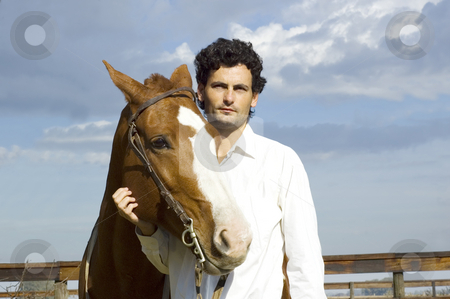 To use this stock image in your creative project, please select the size you need over to the right and click the "Add to Cart" button.
Your downloaded image will come with the Cutcaster watermark removed so don’t worry about the watermark you see on this page. Man and horse stock photo, A young latin man standing with his horse on a cloudy day by Lee Torrens