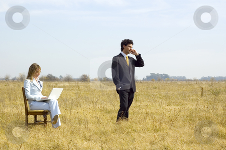 To use this stock image in your creative project, please select the size you need over to the right and click the "Add to Cart" button.
Your downloaded image will come with the Cutcaster watermark removed so don’t worry about the watermark you see on this page. Business Team Working Outdoors stock photo, A businessman and businesswoman working in the middle of a dry field. by Lee Torrens