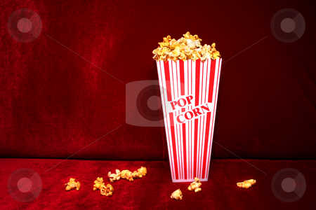 To use this stock image in your creative project, please select the size you need over to the right and click the "Add to Cart" button.
Your downloaded image will come with the Cutcaster watermark removed so don’t worry about the watermark you see on this page. Popcorn stock photo, Theater-style popcorn spilled from tub onto red velvet seat. by Clay Anthony