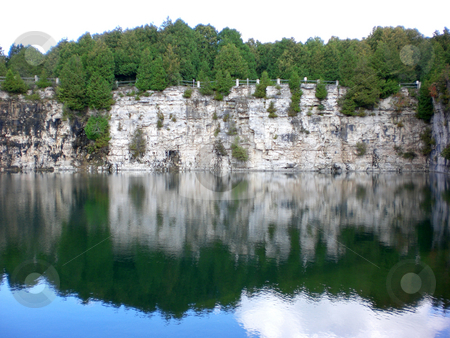 To use this stock image in your creative project, please select the size you need over to the right and click the "Add to Cart" button.
Your downloaded image will come with the Cutcaster watermark removed so don’t worry about the watermark you see on this page. Quarry cliff with reflection stock photo, by J.G. Byers