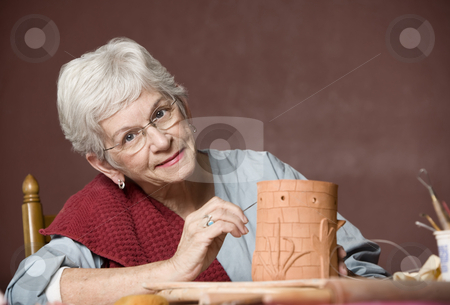 To use this stock image in your creative project, please select the size you need over to the right and click the "Add to Cart" button.
Your downloaded image will come with the Cutcaster watermark removed so don’t worry about the watermark you see on this page. Woman working with clay stock photo, Senior woman working on a clay sculpture by Scott Griessel