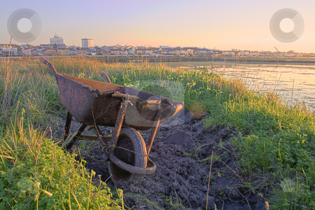 To use this stock image in your creative project, please select the size you need over to the right and click the "Add to Cart" button.
Your downloaded image will come with the Cutcaster watermark removed so don’t worry about the watermark you see on this page. A rusty wheelbarrow stock photo, A rusty wheelbarrow abondon with the city in the background by Paulo Resende