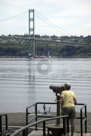 To use this stock image in your creative project, please select the size you need over to the right and click the "Add to Cart" button.
Your downloaded image will come with the Cutcaster watermark removed so don’t worry about the watermark you see on this page. Tacoma Narrows Bridge stock photo, July 14, 2004 : A park patron looks through a telescope at the Narrows Bridge Park in Gig Harbor, Washington. The park has a telescope set up so people can get a up close look at the construction of the new Narrows Bridge thats being built. by Jesse Beals