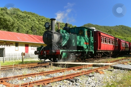 To use this stock image in your creative project, please select the size you need over to the right and click the "Add to Cart" button.
Your downloaded image will come with the Cutcaster watermark removed so don’t worry about the watermark you see on this page. Steam Train stock photo, A green locomotive hauls red carriages past a period hotel on the West Coast Wilderness Railway, as it travels from Queenstown to Strahan. Tasmania, Australia by Martin Darley