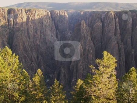 To use this stock image in your creative project, please select the size you need over to the right and click the "Add to Cart" button.
Your downloaded image will come with the Cutcaster watermark removed so don’t worry about the watermark you see on this page. Black Canyon of the Gunnison at sunrise stock photo, Despite the coloration of those trees, this shot is from July. Taken from the road around the south/west rim of the Black Canyon of the Gunnison. by JKJ Anderson