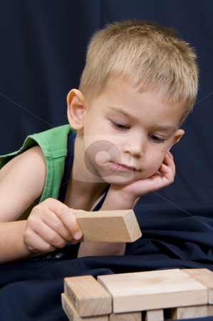 To use this stock image in your creative project, please select the size you need over to the right and click the "Add to Cart" button.
Your downloaded image will come with the Cutcaster watermark removed so don’t worry about the watermark you see on this page. Little boy playing on black background stock photo, A cute little 3 year old boy playing on a black background with some wooden blocks. by Nicolaas Traut