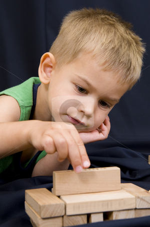 To use this stock image in your creative project, please select the size you need over to the right and click the "Add to Cart" button.
Your downloaded image will come with the Cutcaster watermark removed so don’t worry about the watermark you see on this page. Little boy playing on black background stock photo, A cute little 3 year old boy playing on a black background with some wooden blocks. by Nicolaas Traut
