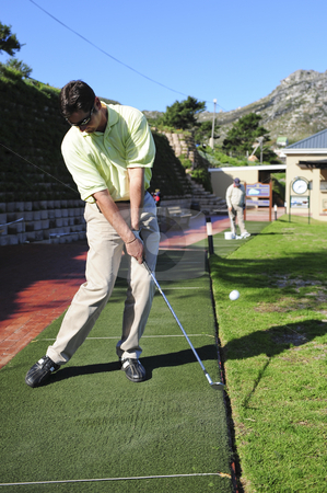 To use this stock image in your creative project, please select the size you need over to the right and click the "Add to Cart" button.
Your downloaded image will come with the Cutcaster watermark removed so don’t worry about the watermark you see on this page. Handsome young golfer in action stock photo, A golfer in action on a practice or driving range, hitting the ball with a club. by Nicolaas Traut