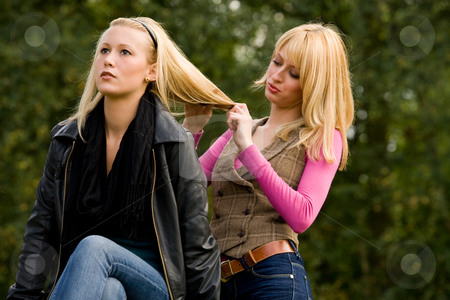 To use this stock image in your creative project, please select the size you need over to the right and click the "Add to Cart" button.
Your downloaded image will come with the Cutcaster watermark removed so don’t worry about the watermark you see on this page. Concentrated on her hair stock photo, Two sisters in a park having fun by Frenk and Danielle Kaufmann