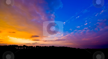 To use this stock image in your creative project, please select the size you need over to the right and click the "Add to Cart" button.
Your downloaded image will come with the Cutcaster watermark removed so don’t worry about the watermark you see on this page. Blue sunset stock photo, Sunset with a piece of blue sky and silhouette of a landscape by Karin Claus