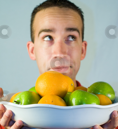 To use this stock image in your creative project, please select the size you need over to the right and click the "Add to Cart" button.
Your downloaded image will come with the Cutcaster watermark removed so don’t worry about the watermark you see on this page. Healthy Snack stock photo, A young man holding a bowl of healthy apples and oranges by Richard Nelson