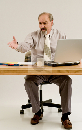To use this stock image in your creative project, please select the size you need over to the right and click the "Add to Cart" button.
Your downloaded image will come with the Cutcaster watermark removed so don’t worry about the watermark you see on this page. Businessman gestures as he offers solution stock photo, Businessman seated at a table with files and a laptop by RCarner Photography