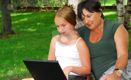 To use this stock image in your creative project, please select the size you need over to the right and click the "Add to Cart" button.
Your downloaded image will come with the Cutcaster watermark removed so don’t worry about the watermark you see on this page. Family computer stock photo, Grandmother and granddaughter sitting outside with laptop computer by Elena Elisseeva