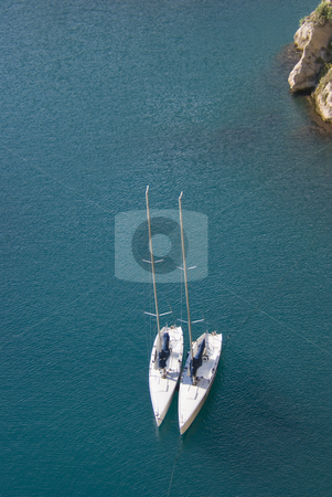 To use this stock image in your creative project, please select the size you need over to the right and click the "Add to Cart" button.
Your downloaded image will come with the Cutcaster watermark removed so don’t worry about the watermark you see on this page. Sailboats stock photo, Aerial view of two white sailboats in a deep blue lagoon. Mediterranean sea - French Riviera. by Serge VILLA
