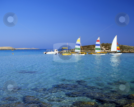 To use this stock image in your creative project, please select the size you need over to the right and click the "Add to Cart" button.
Your downloaded image will come with the Cutcaster watermark removed so don’t worry about the watermark you see on this page. Just fun stock photo, Bright pleasure sailboats by rocks in the shallow water of Nissi Beach, Cyprus by Paul Phillips