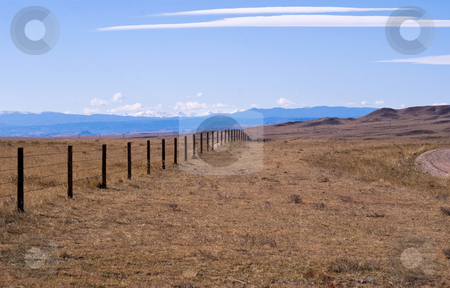 To use this stock image in your creative project, please select the size you need over to the right and click the "Add to Cart" button.
Your downloaded image will come with the Cutcaster watermark removed so don’t worry about the watermark you see on this page. Cattle fence on the high plains stock photo, Rocky Mountains in the background of a high plains drift fence. by RCarner Photography
