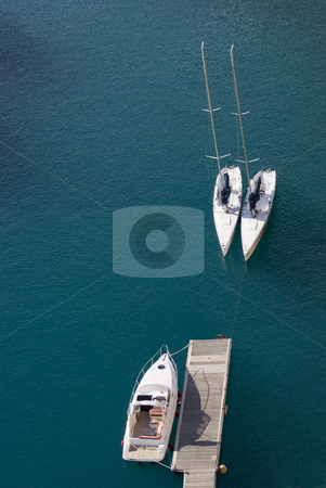 To use this stock image in your creative project, please select the size you need over to the right and click the "Add to Cart" button.
Your downloaded image will come with the Cutcaster watermark removed so don’t worry about the watermark you see on this page. Boats stock photo, Aerial view of two sailboats and one motorboat in a deep blue lagoon. Mediterranean sea - French Riviera. by Serge VILLA
