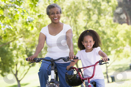 To use this stock image in your creative project, please select the size you need over to the right and click the "Add to Cart" button.
Your downloaded image will come with the Cutcaster watermark removed so don’t worry about the watermark you see on this page. Grandmother and granddaughter on bikes outdoors smiling stock photo, by Monkey Business Images