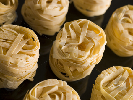 To use this stock image in your creative project, please select the size you need over to the right and click the "Add to Cart" button.
Your downloaded image will come with the Cutcaster watermark removed so don’t worry about the watermark you see on this page. Dried Tagliatelle Nests stock photo, Close up of Dried Tagliatelle Nests by Monkey Business Images