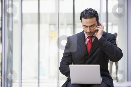 To use this stock image in your creative project, please select the size you need over to the right and click the "Add to Cart" button.
Your downloaded image will come with the Cutcaster watermark removed so don’t worry about the watermark you see on this page. Businessman using laptop and mobile outside stock photo, Businessman using laptop and mobile outside office by Monkey Business Images