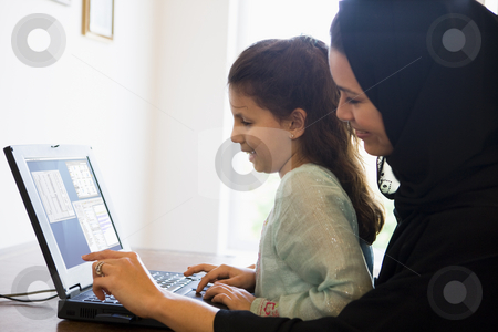 To use this stock image in your creative project, please select the size you need over to the right and click the "Add to Cart" button.
Your downloaded image will come with the Cutcaster watermark removed so don’t worry about the watermark you see on this page. A Middle Eastern woman and her daughter sitting in front of a co stock photo, by Monkey Business Images