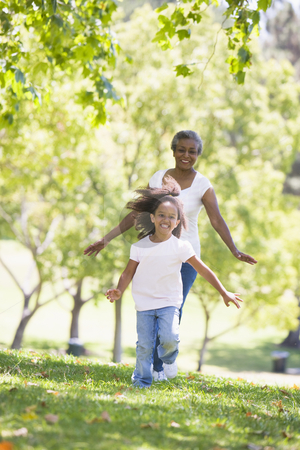 To use this stock image in your creative project, please select the size you need over to the right and click the "Add to Cart" button.
Your downloaded image will come with the Cutcaster watermark removed so don’t worry about the watermark you see on this page. Grandmother and granddaughter running in park and smiling stock photo, by Monkey Business Images