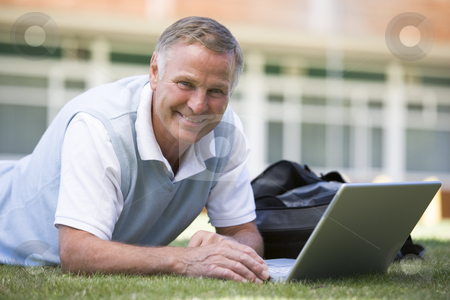 To use this stock image in your creative project, please select the size you need over to the right and click the "Add to Cart" button.
Your downloaded image will come with the Cutcaster watermark removed so don’t worry about the watermark you see on this page. Man using laptop while lying in grass on campus stock photo, by Monkey Business Images