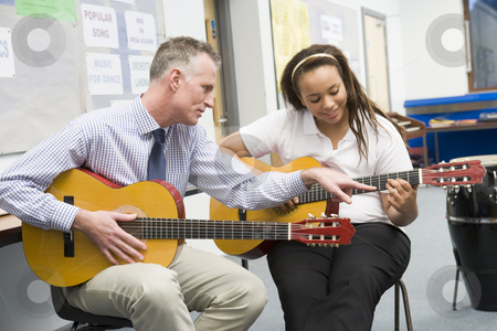 To use this stock image in your creative project, please select the size you need over to the right and click the "Add to Cart" button.
Your downloaded image will come with the Cutcaster watermark removed so don’t worry about the watermark you see on this page. Schoolgirl and teacher playing guitar in music class stock photo, by Monkey Business Images