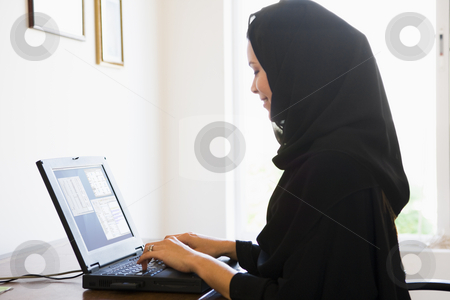 To use this stock image in your creative project, please select the size you need over to the right and click the "Add to Cart" button.
Your downloaded image will come with the Cutcaster watermark removed so don’t worry about the watermark you see on this page. A Middle Eastern woman sitting in front of a computer at home stock photo, by Monkey Business Images