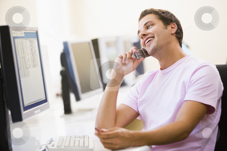 To use this stock image in your creative project, please select the size you need over to the right and click the "Add to Cart" button.
Your downloaded image will come with the Cutcaster watermark removed so don’t worry about the watermark you see on this page. Man sitting in computer room using cellular phone and smiling stock photo, by Monkey Business Images