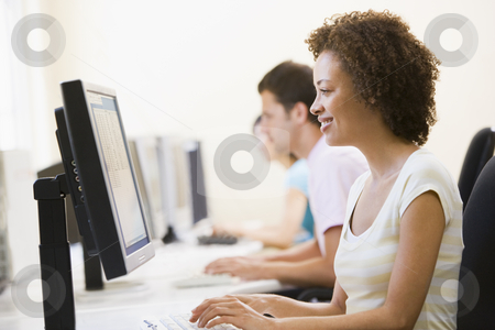 To use this stock image in your creative project, please select the size you need over to the right and click the "Add to Cart" button.
Your downloaded image will come with the Cutcaster watermark removed so don’t worry about the watermark you see on this page. Three people sitting in computer room typing and smiling stock photo, by Monkey Business Images
