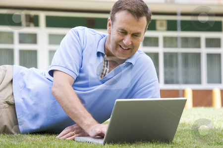 To use this stock image in your creative project, please select the size you need over to the right and click the "Add to Cart" button.
Your downloaded image will come with the Cutcaster watermark removed so don’t worry about the watermark you see on this page. Man using laptop while lying in grass on campus stock photo, by Monkey Business Images