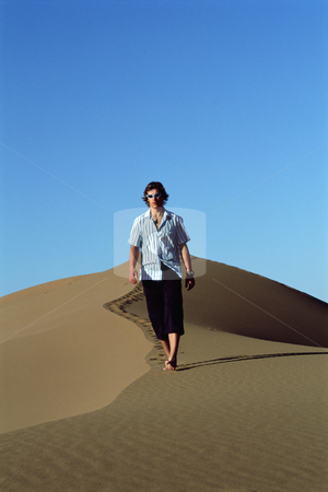 To use this stock image in your creative project, please select the size you need over to the right and click the "Add to Cart" button.
Your downloaded image will come with the Cutcaster watermark removed so don’t worry about the watermark you see on this page. Young man walking along sand dune stock photo, by Monkey Business Images