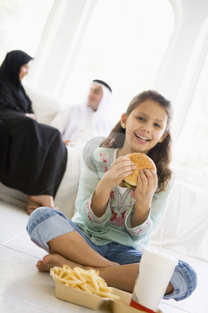To use this stock image in your creative project, please select the size you need over to the right and click the "Add to Cart" button.
Your downloaded image will come with the Cutcaster watermark removed so don’t worry about the watermark you see on this page. A Middle Eastern girl enjoying a fast food burger meal stock photo, by Monkey Business Images