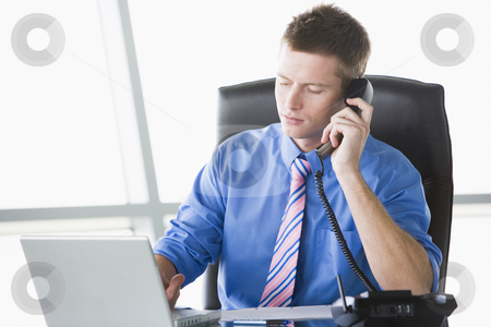 To use this stock image in your creative project, please select the size you need over to the right and click the "Add to Cart" button.
Your downloaded image will come with the Cutcaster watermark removed so don’t worry about the watermark you see on this page. Businessman sitting in office with laptop on telephone stock photo, by Monkey Business Images