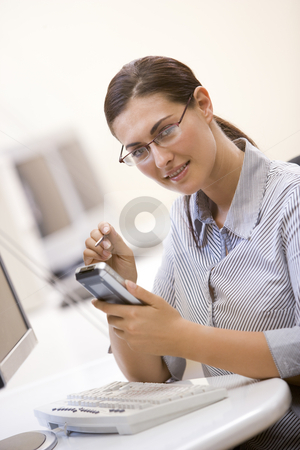 To use this stock image in your creative project, please select the size you need over to the right and click the "Add to Cart" button.
Your downloaded image will come with the Cutcaster watermark removed so don’t worry about the watermark you see on this page. Woman in computer room using personal digital assistant and smil stock photo, by Monkey Business Images