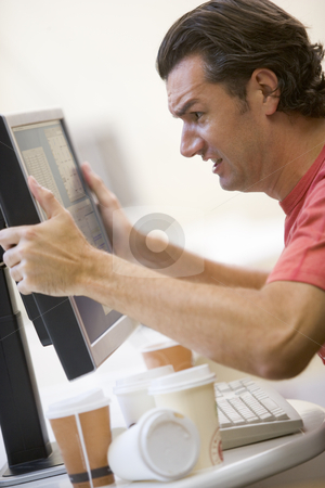 To use this stock image in your creative project, please select the size you need over to the right and click the "Add to Cart" button.
Your downloaded image will come with the Cutcaster watermark removed so don’t worry about the watermark you see on this page. Man in computer room with many empty cups of coffee grabbing his stock photo, by Monkey Business Images