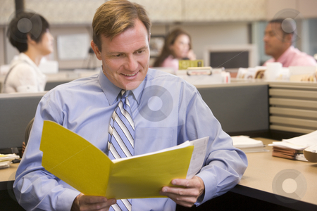 To use this stock image in your creative project, please select the size you need over to the right and click the "Add to Cart" button.
Your downloaded image will come with the Cutcaster watermark removed so don’t worry about the watermark you see on this page. Businessman in cubicle with folder smiling stock photo, by Monkey Business Images