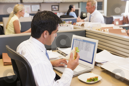 To use this stock image in your creative project, please select the size you need over to the right and click the "Add to Cart" button.
Your downloaded image will come with the Cutcaster watermark removed so don’t worry about the watermark you see on this page. Businessman in cubicle at laptop eating sandwich stock photo, by Monkey Business Images