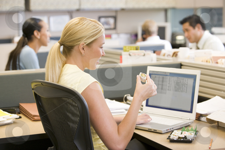 To use this stock image in your creative project, please select the size you need over to the right and click the "Add to Cart" button.
Your downloaded image will come with the Cutcaster watermark removed so don’t worry about the watermark you see on this page. Businesswoman in cubicle using laptop eating sushi stock photo, by Monkey Business Images